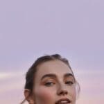 AI-generated Instagram reel cover with a woman against a lavender to sunset pink gradient sky background with large empty space at the top half of the frame perfect for reel title text overlay